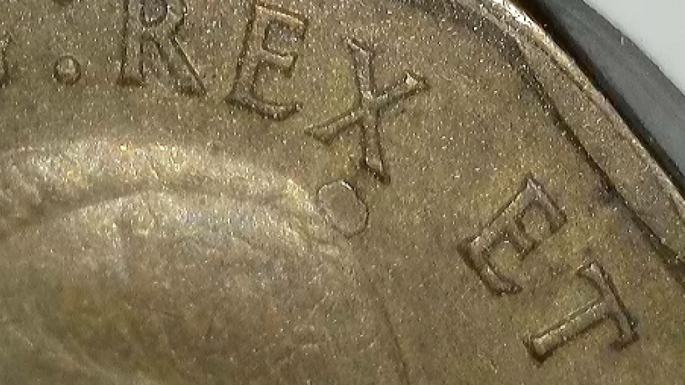1942 Canadian tombac five-cent coin with localized raised irregularity and disturbed surface near lettering